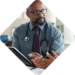 A photo of a male physician looking at an off-screen patient